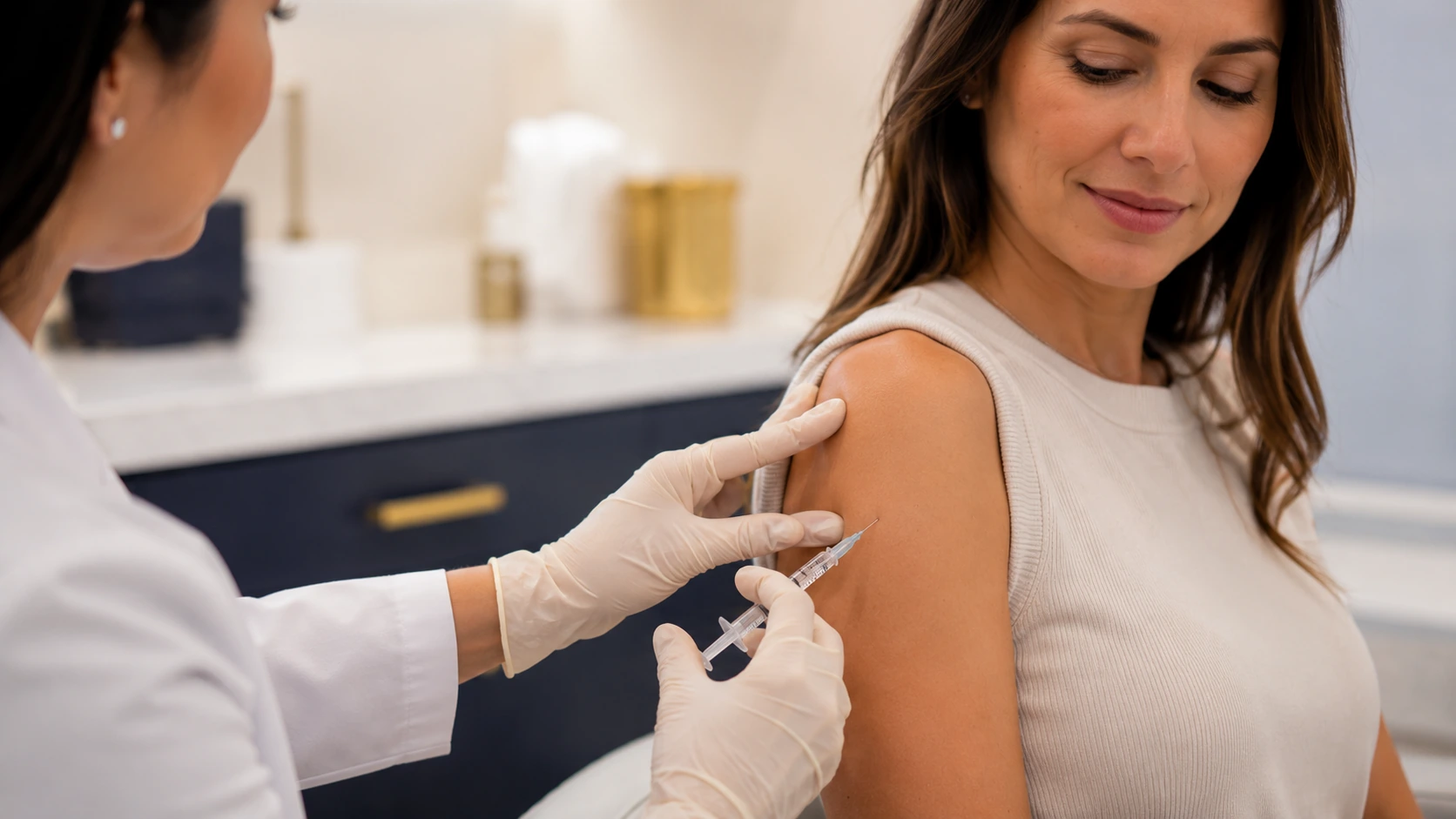 Licensed clinician administering an intramuscular wellness injection in the upper arm