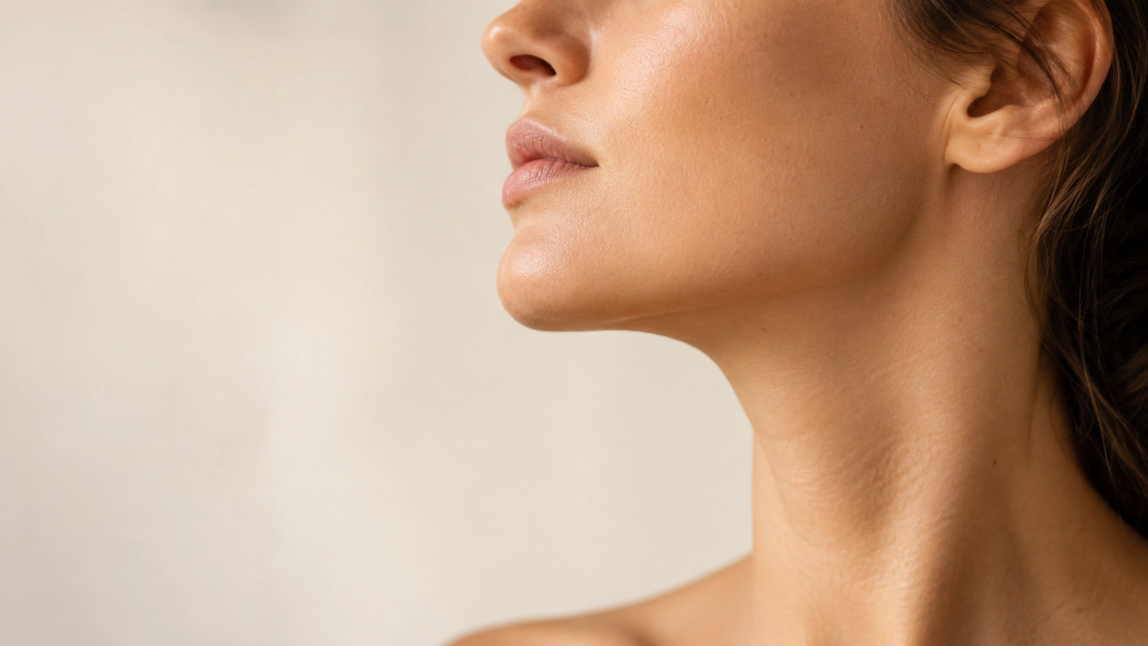 Close-up profile view of a woman's jawline and neck showing a defined contour